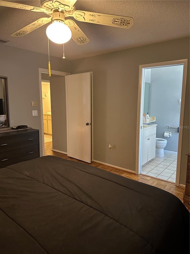 unfurnished bedroom featuring a textured ceiling, connected bathroom, and baseboards