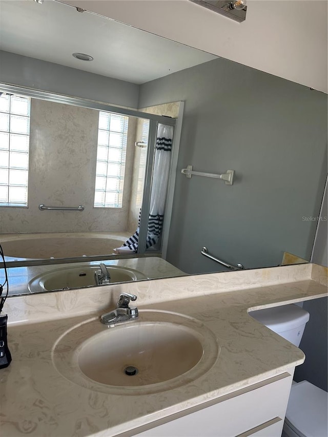 bathroom with toilet, a bathing tub, and vanity