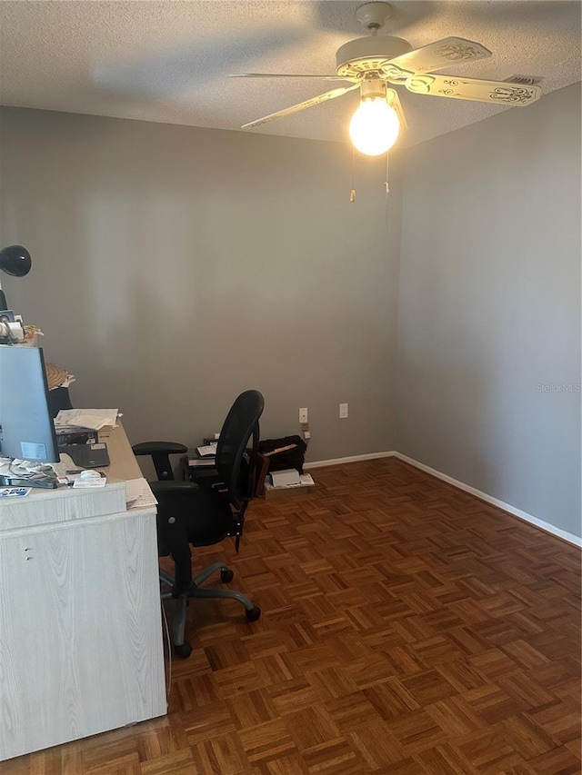 office space with a ceiling fan, a textured ceiling, and baseboards