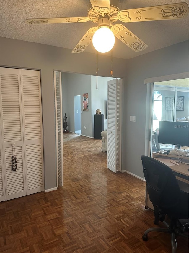 home office featuring a ceiling fan, a textured ceiling, and baseboards