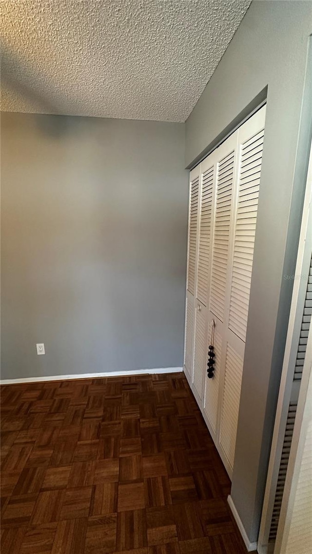 hallway with baseboards and a textured ceiling