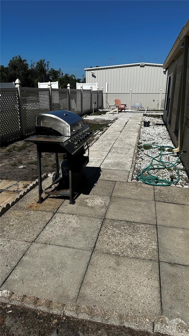 view of patio featuring a grill and fence