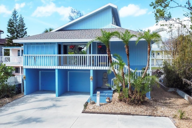 view of front facade with driveway and a shingled roof