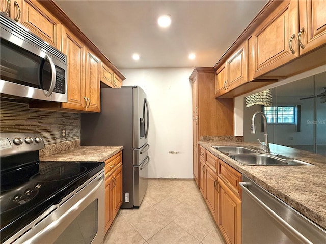 kitchen featuring light tile patterned floors, stainless steel appliances, backsplash, and sink