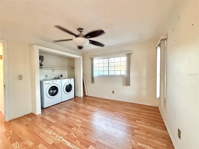 washroom with light wood-type flooring, washer and dryer, ceiling fan, and a textured ceiling