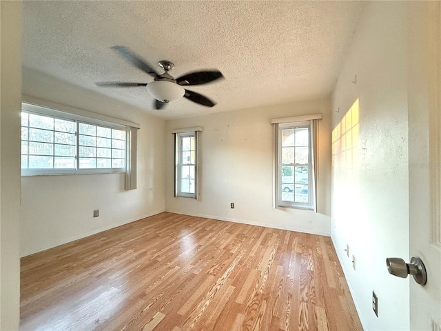 empty room featuring ceiling fan, light hardwood / wood-style floors, and a textured ceiling