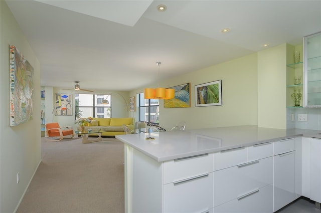 kitchen with white cabinets, modern cabinets, a peninsula, light countertops, and carpet floors