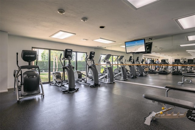 workout area with a textured ceiling and baseboards