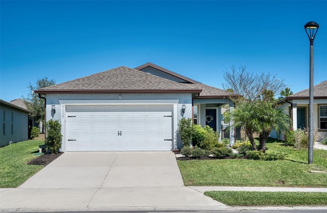 ranch-style home featuring a garage, driveway, a shingled roof, and a front lawn