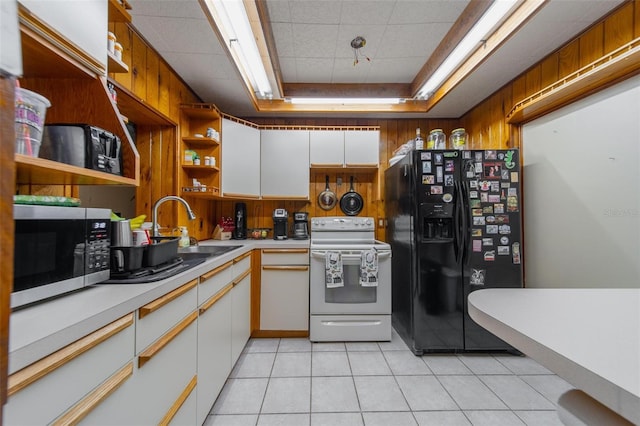 kitchen featuring a tray ceiling, white electric stove, stainless steel microwave, black fridge with ice dispenser, and a sink