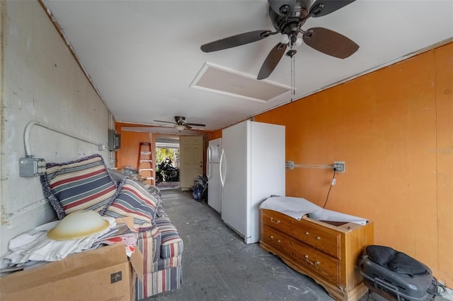 bedroom with attic access, freestanding refrigerator, unfinished concrete flooring, and a ceiling fan