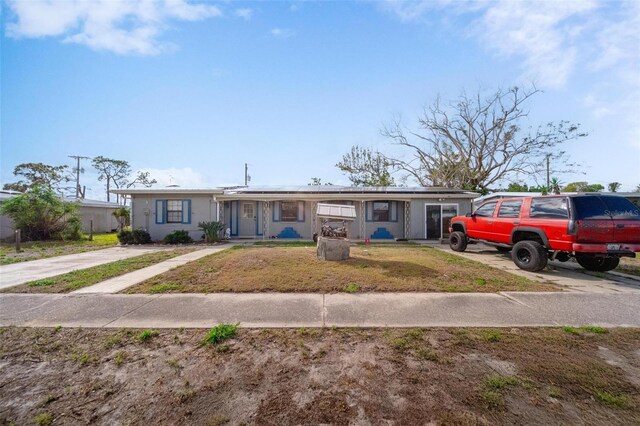 view of front of house featuring solar panels and a front yard