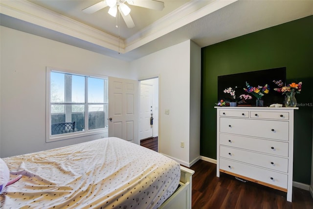 bedroom with a tray ceiling, ornamental molding, ceiling fan, and dark hardwood / wood-style flooring