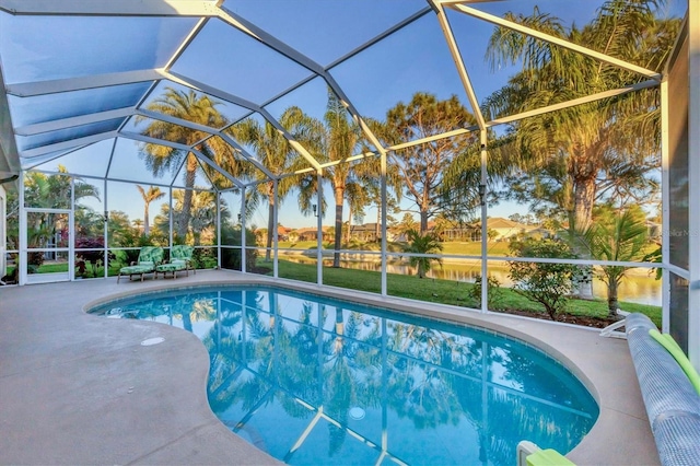 view of swimming pool with a patio, glass enclosure, and a water view