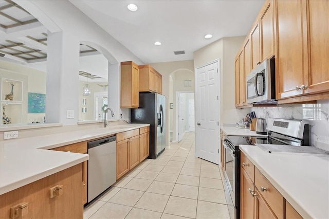 kitchen with light tile patterned floors, stainless steel appliances, backsplash, and sink