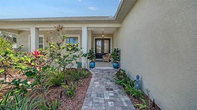 entrance to property with french doors and stucco siding