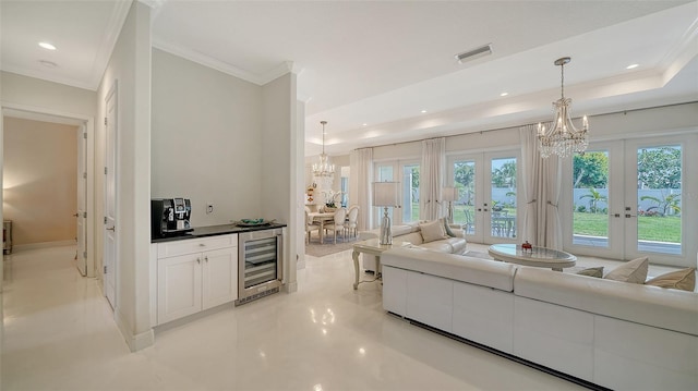 living area with an inviting chandelier, beverage cooler, visible vents, and french doors