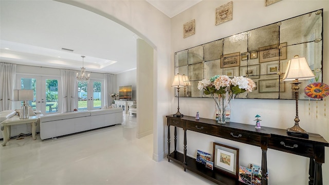 hall with arched walkways, concrete floors, visible vents, french doors, and a raised ceiling