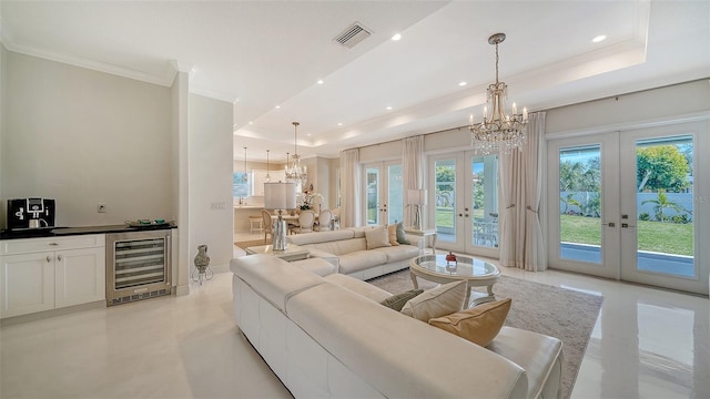 living room with a tray ceiling, french doors, and beverage cooler