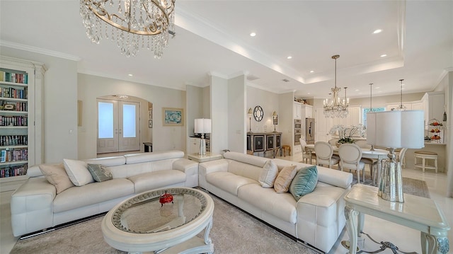 living room with a tray ceiling, french doors, crown molding, recessed lighting, and an inviting chandelier