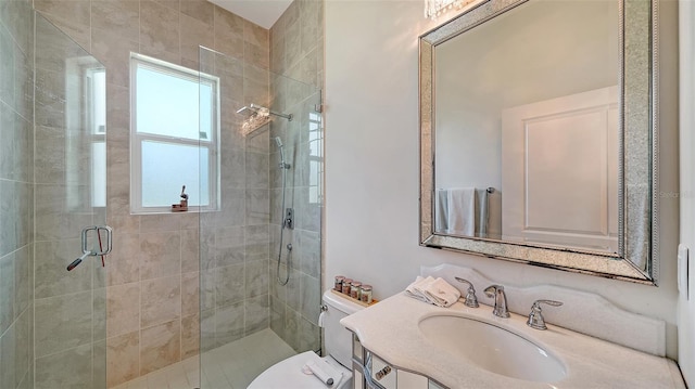 bathroom featuring toilet, a shower stall, and vanity