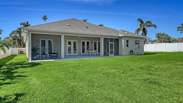 back of house with a yard, ceiling fan, a fenced backyard, and french doors