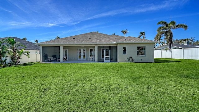 rear view of property with stucco siding, a fenced backyard, and a yard