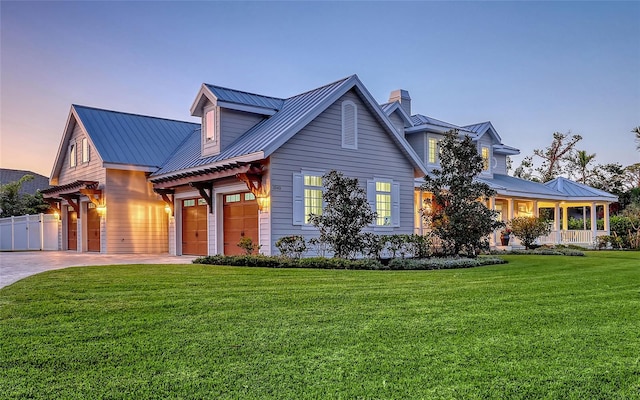 view of front of property with a garage, a yard, and covered porch