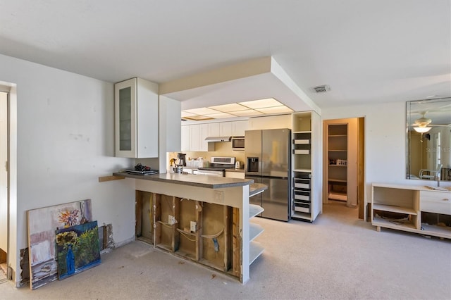 kitchen featuring appliances with stainless steel finishes, ceiling fan, kitchen peninsula, and white cabinets