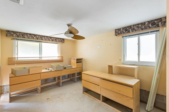 carpeted home office featuring ceiling fan and a textured ceiling