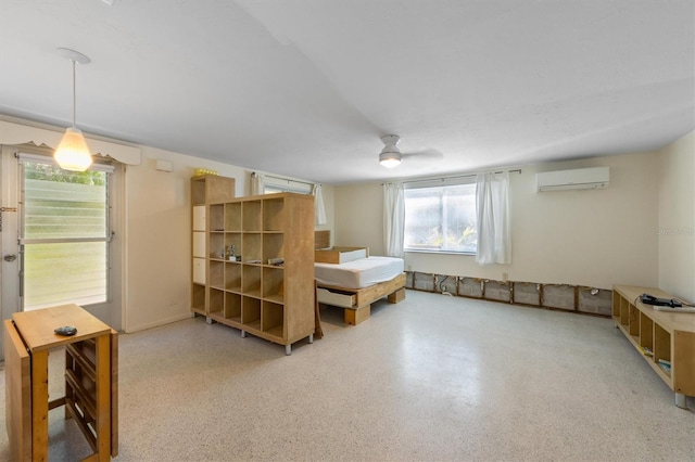 bedroom featuring a wall mounted air conditioner and ceiling fan