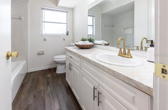 full bathroom featuring tiled shower / bath combo, vanity, toilet, and hardwood / wood-style floors