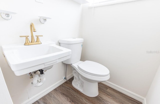 bathroom featuring sink, toilet, and wood-type flooring