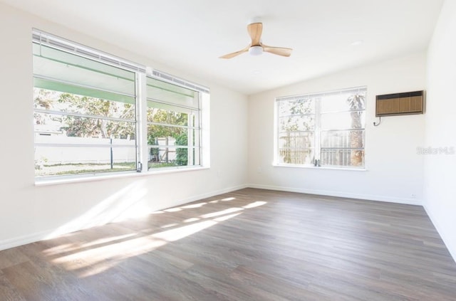 empty room featuring vaulted ceiling, a wall mounted air conditioner, dark hardwood / wood-style floors, and ceiling fan