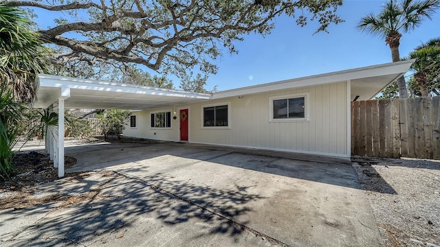 single story home with driveway, fence, and a carport