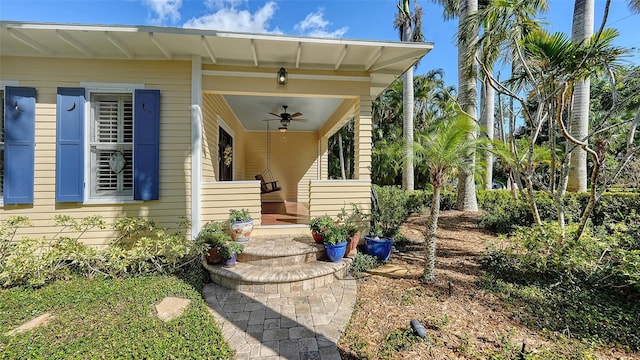 view of exterior entry featuring covered porch and ceiling fan