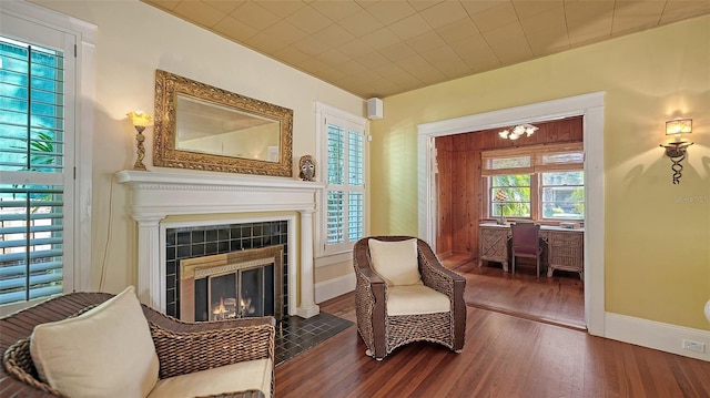 living area with a fireplace, baseboards, and wood finished floors