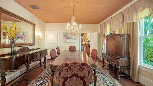 dining space with dark wood-style floors, plenty of natural light, visible vents, and an inviting chandelier