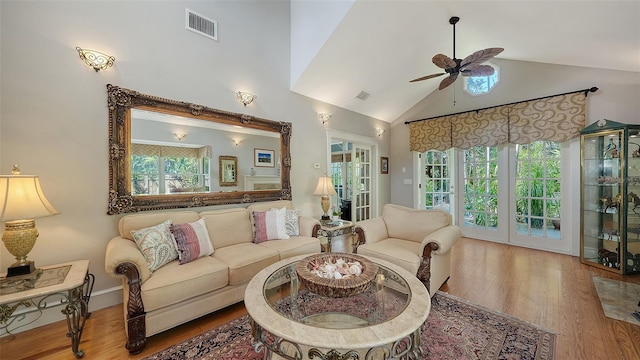 living area with ceiling fan, plenty of natural light, and wood finished floors