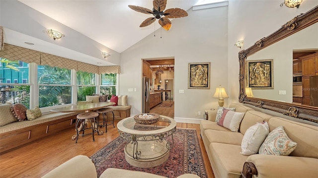 living room featuring wood finished floors, high vaulted ceiling, and a ceiling fan