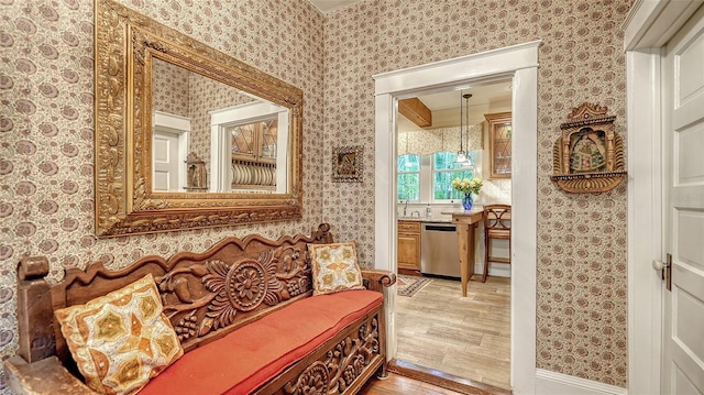 sitting room with light wood-style floors and wallpapered walls