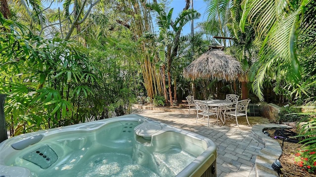 view of swimming pool with a patio area, outdoor dining area, and a hot tub