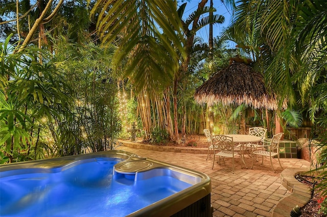 view of swimming pool featuring a patio, outdoor dining area, and a hot tub