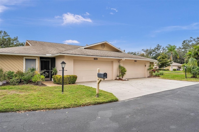 single story home with a garage and a front lawn