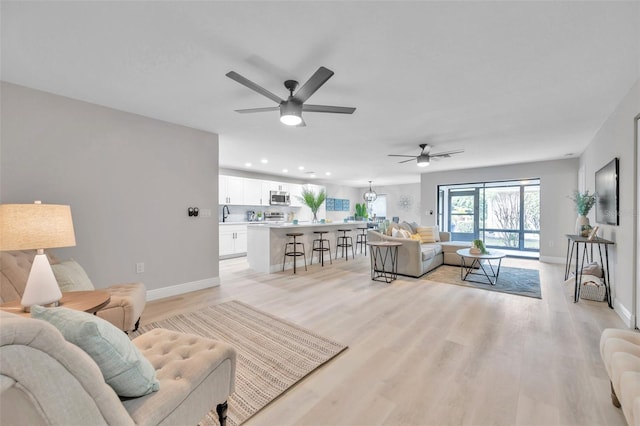 living room featuring light hardwood / wood-style flooring and ceiling fan