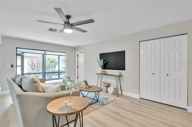 living room with ceiling fan and light hardwood / wood-style floors