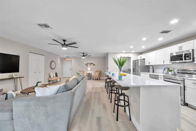 living room featuring light wood-type flooring and ceiling fan