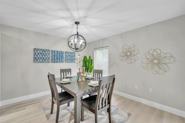 dining room featuring light wood-type flooring and a chandelier