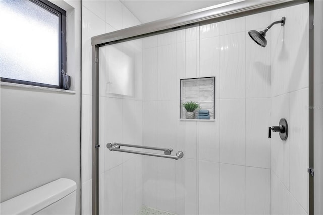 bathroom with an enclosed shower and toilet