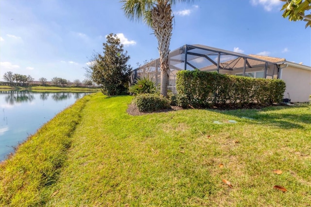 view of yard featuring glass enclosure and a water view